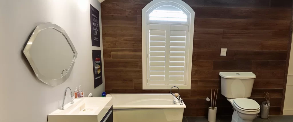 Persiennes blanches installées dans une salle de bain.